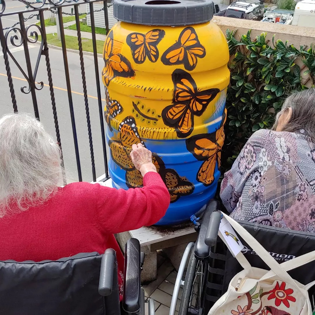 People painting rainbarrel